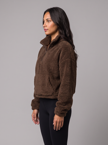Side view of brown fleece half-zip jumper with kangaroo pocket