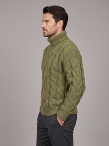 Side view of men's green chunky cable knit roll neck jumper