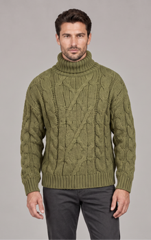 Man wearing olive green chunky cable knit roll neck jumper, front view