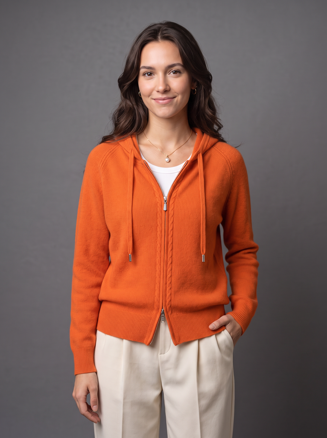 Woman wearing orange knit zip hoodie cardigan, front view
