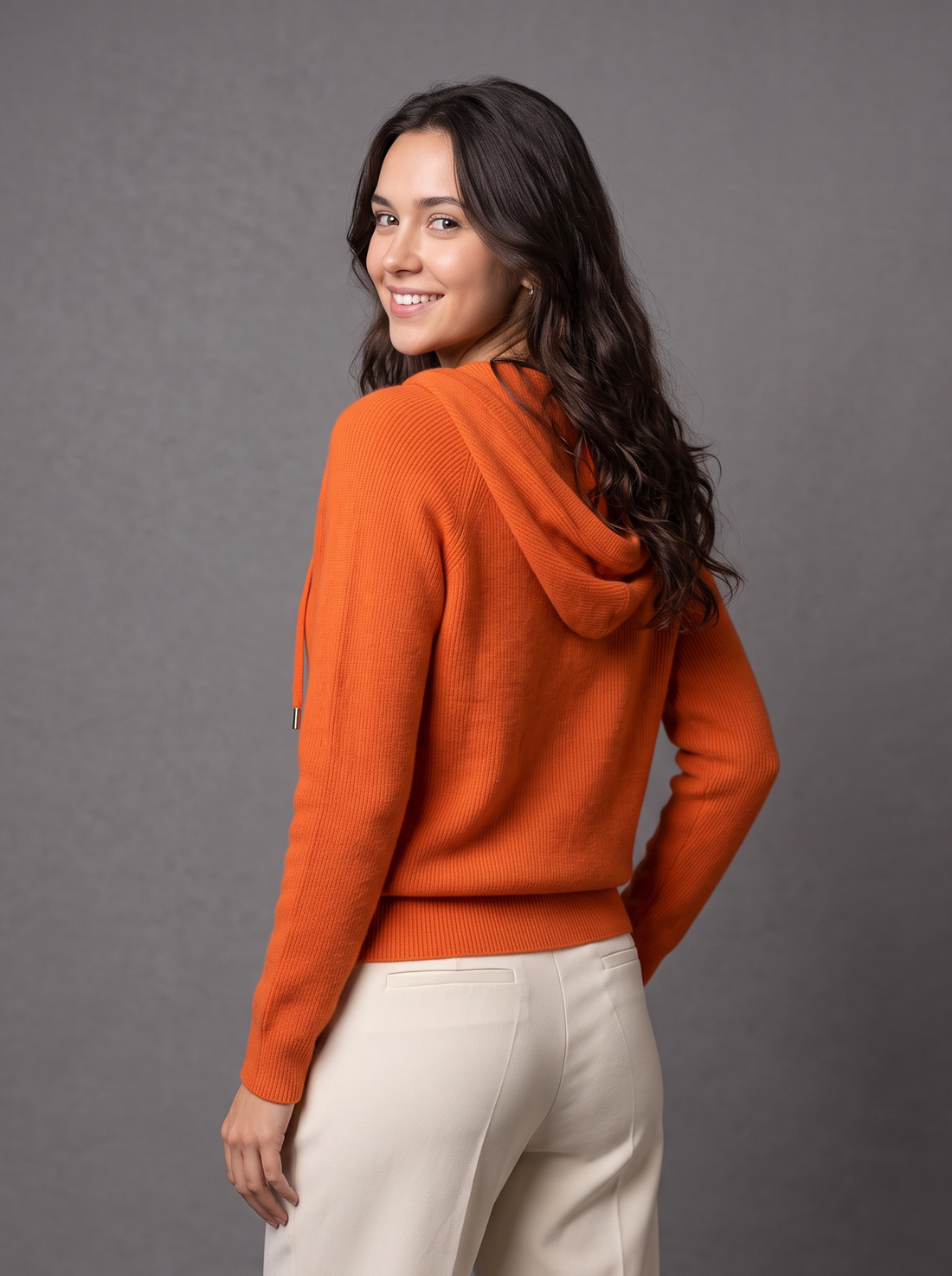 Woman wearing orange knit zip hoodie cardigan, front view
