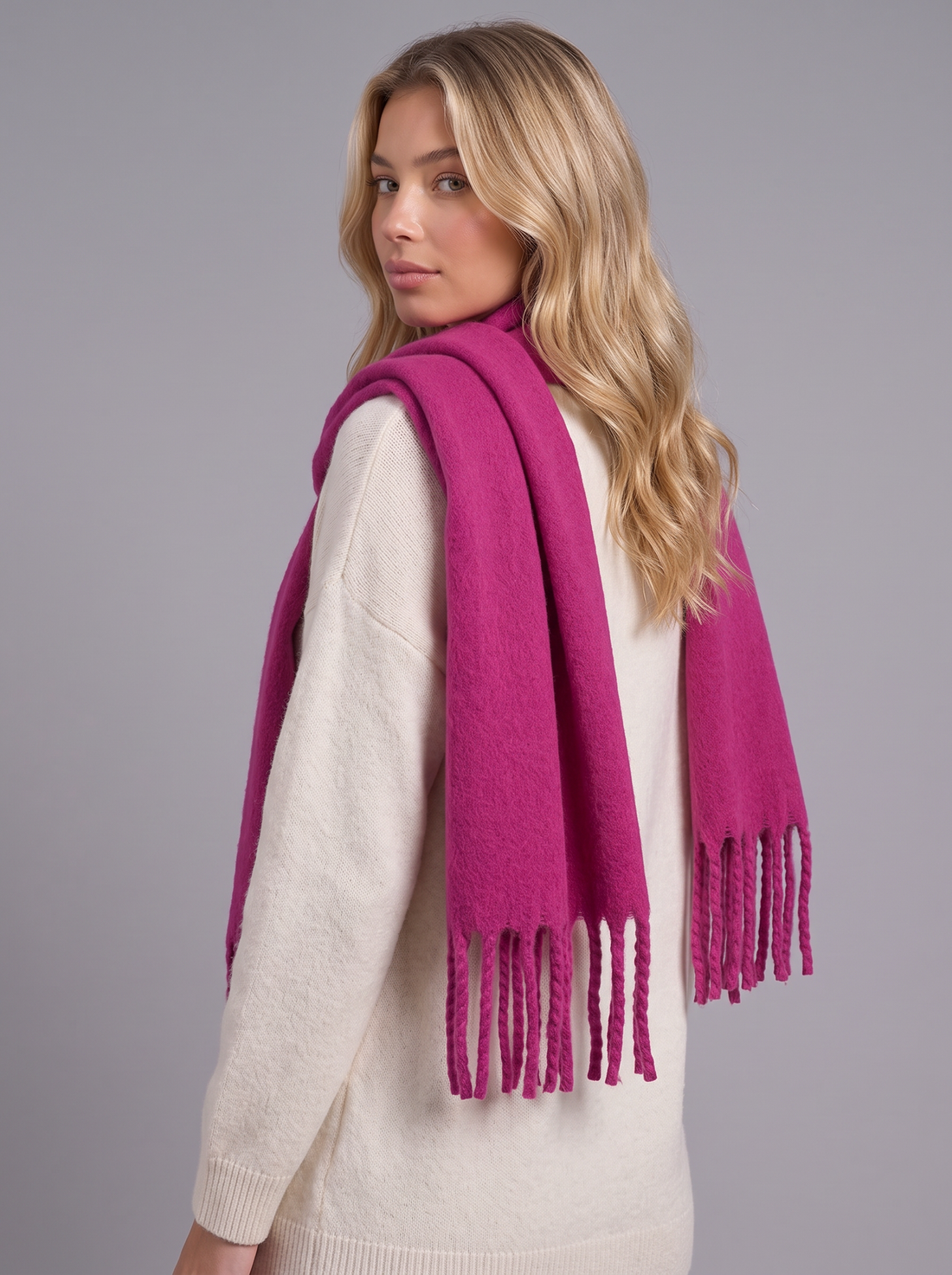Woman wearing magenta tassel cashmere wrap scarf, front view