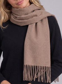 Woman wearing khaki tassel wrap scarf