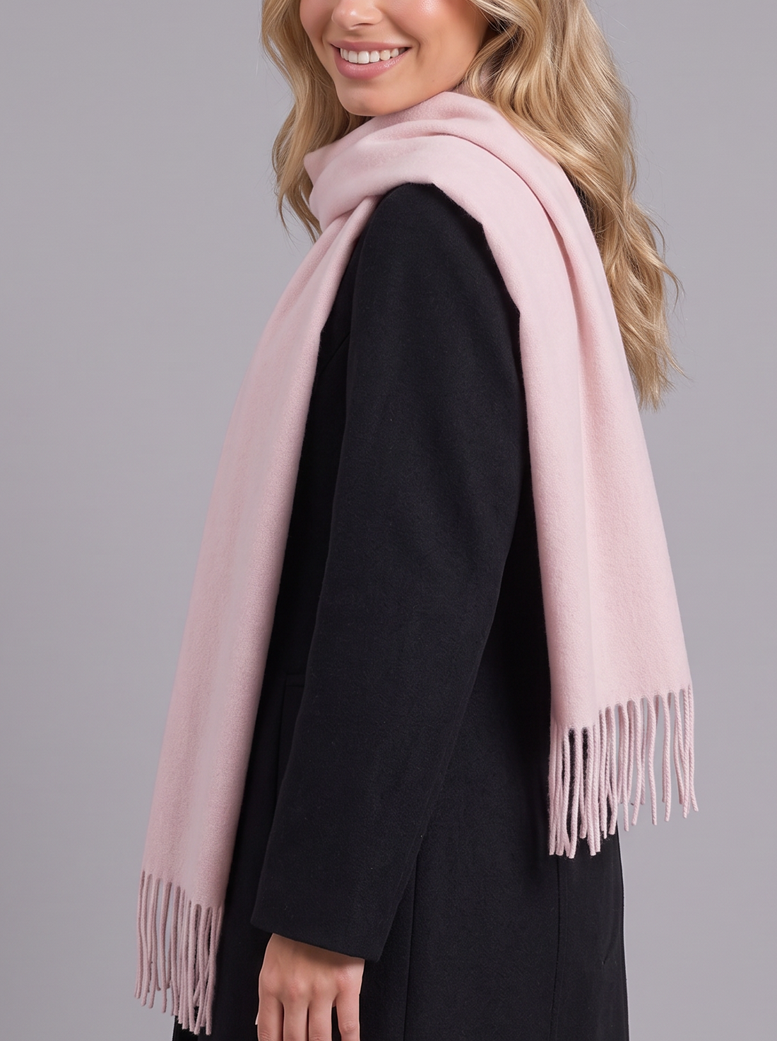 Woman wearing light pink tassel wrap scarf