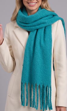 Woman wearing turquoise tassel wrap scarf