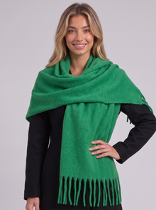 Woman wearing green tassel wrap scarf
