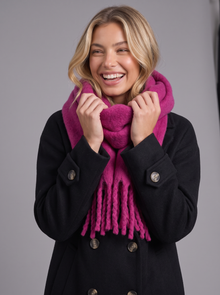 Woman laughing with magenta fringed wrap scarf pulled up to her chin
