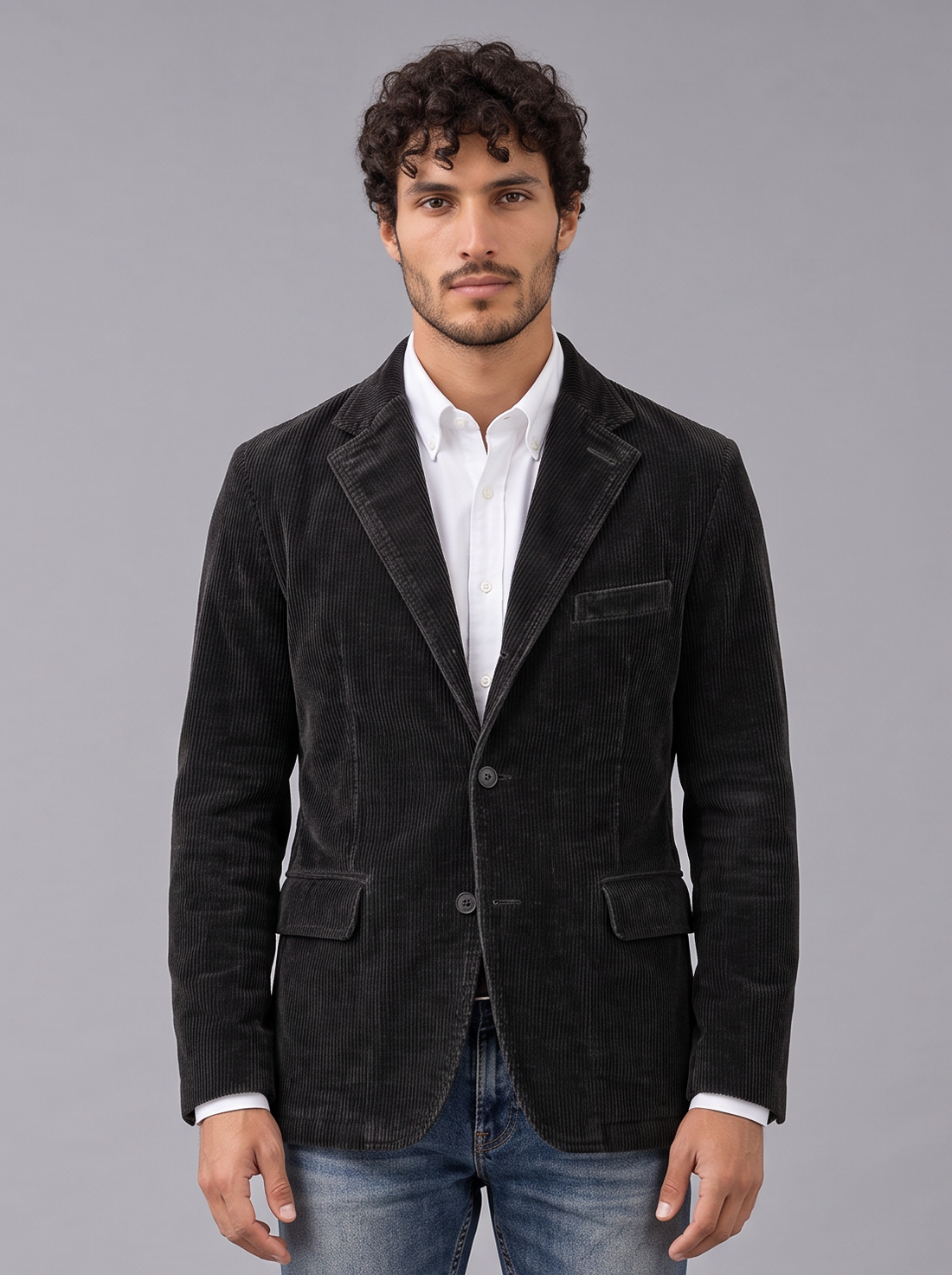 Man wearing black corduroy blazer-style jacket with notch lapels and flap pockets, front view