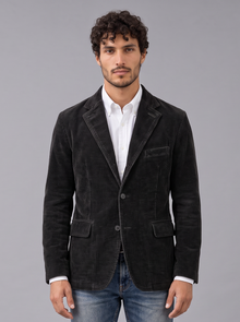 Man wearing black corduroy blazer-style jacket with notch lapels and flap pockets, front view