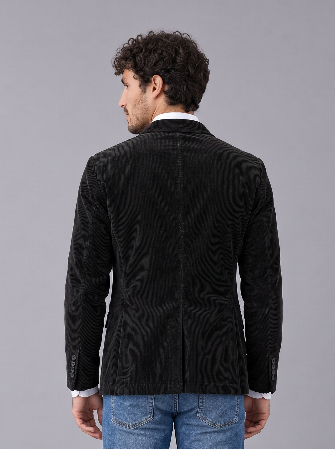 Man wearing black corduroy blazer-style jacket with notch lapels and flap pockets, front view