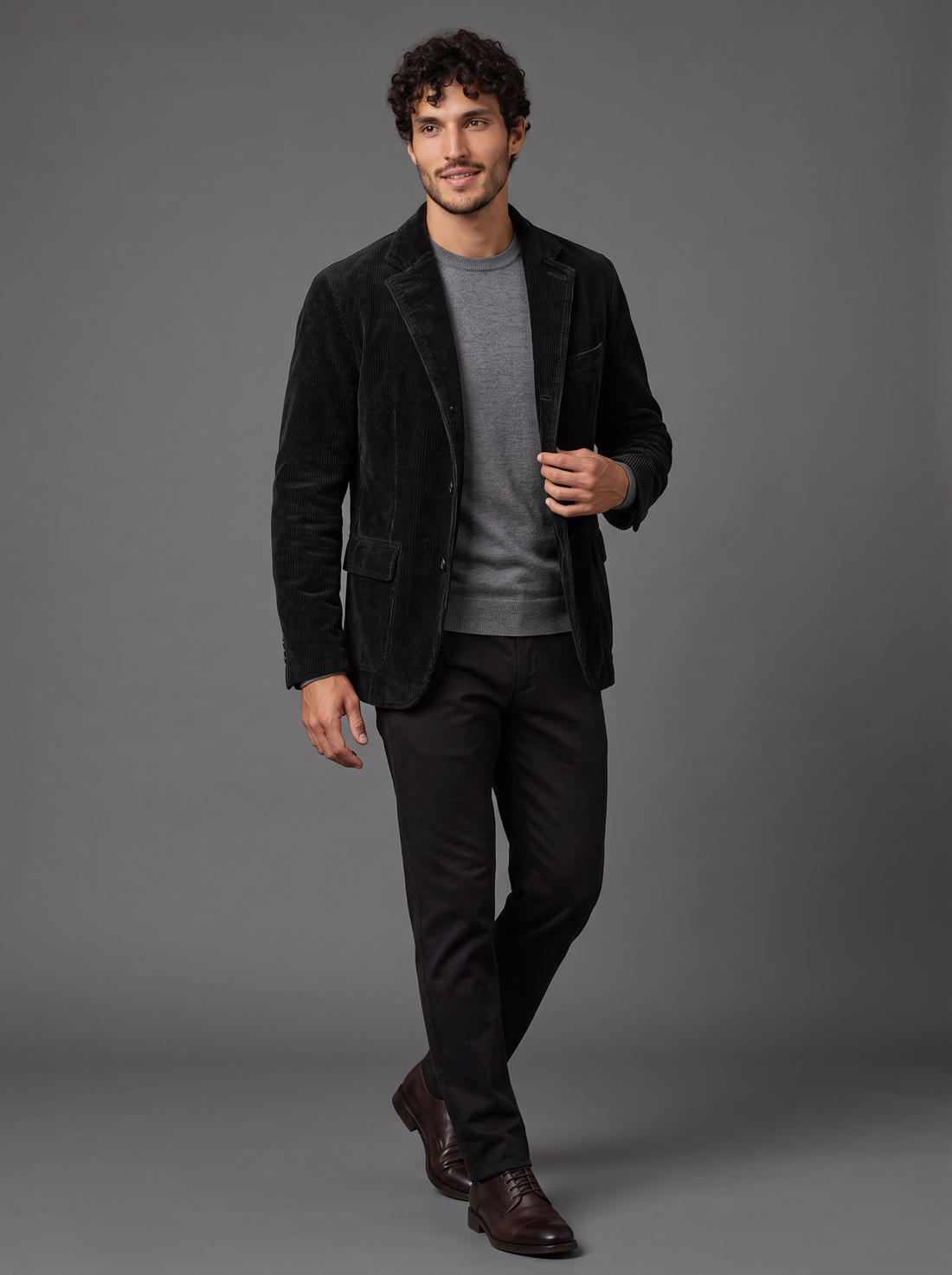 Man walking in open black corduroy blazer-style jacket over grey jumper