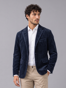 Men's navy corduroy blazer jacket with notch lapels and flap pockets, worn with a white shirt and beige chinos