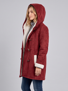 Side view of a red hooded duffle coat with hood up and sherpa lining