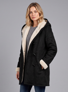 Woman wearing a black hooded duffle coat with sherpa-lined hood and toggle fastening