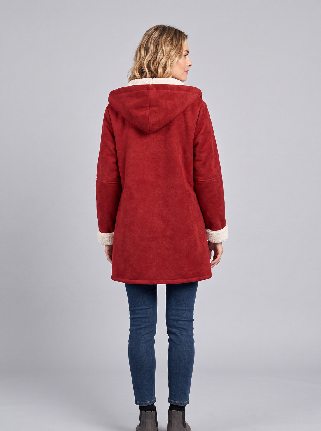 Woman wearing a red hooded duffle coat with toggle fastening and sherpa-lined hood, front view