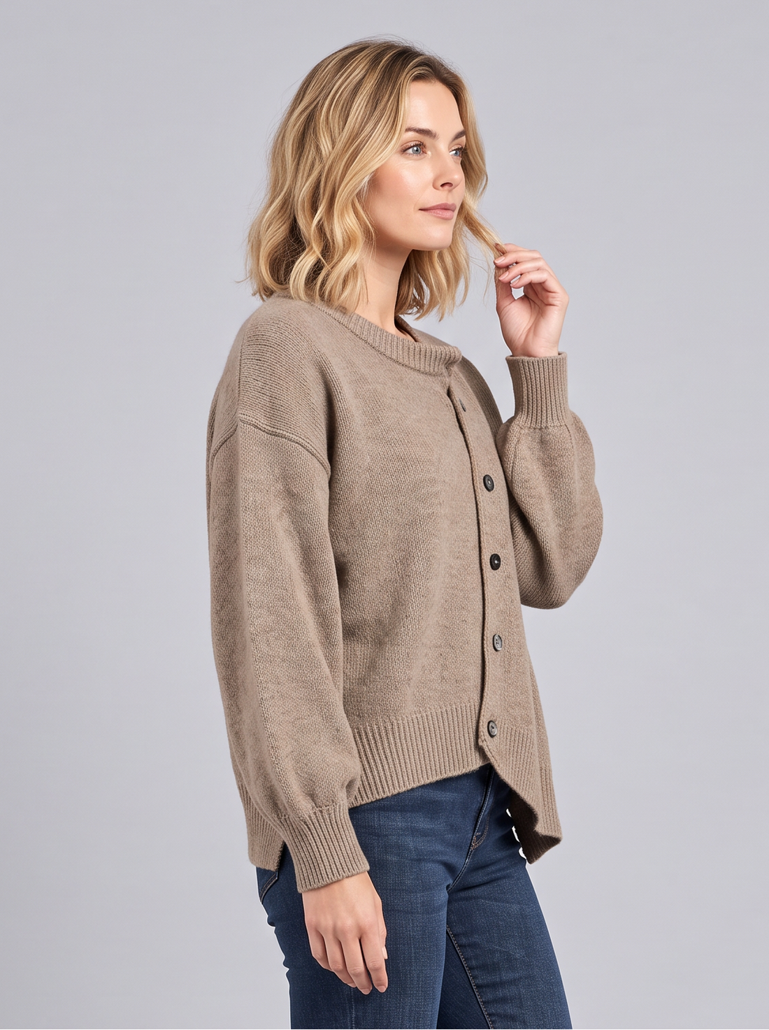 Side view of a brown cashmere button-front jumper worn with dark jeans