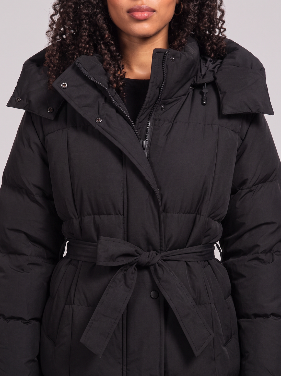 Women's Long Puffer Coat with Hood in Black – close-up of quilting, hood and belt