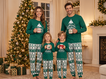 Family wearing matching green Christmas pyjamas