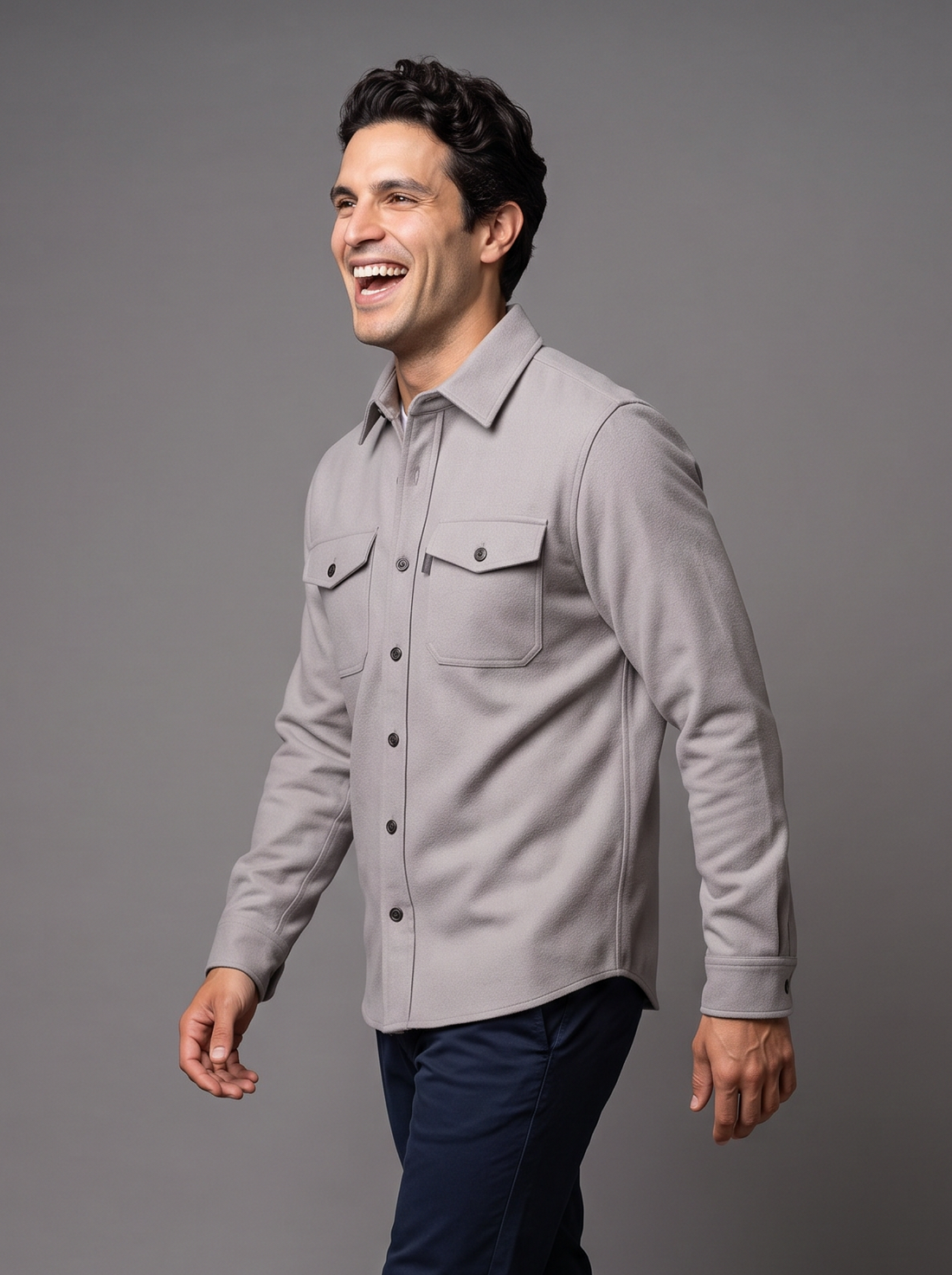 Man walking in a light grey button-up overshirt, side view