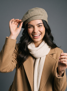 Laughing woman adjusting a khaki knitted beret