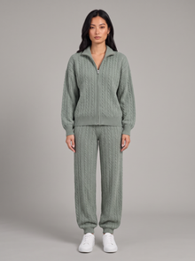 Woman in a sage green cable knit zip cardigan and joggers set, full-length front view