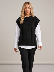 Woman wearing black cable knit round neck sweater vest