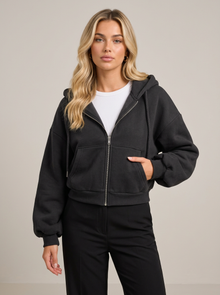 Woman wearing black cropped zip-up fleece-lined hoodie