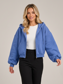 Woman wearing blue cropped zip-up fleece-lined hoodie