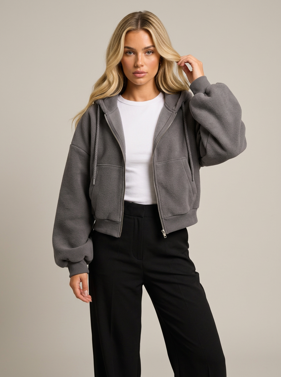 Woman wearing dark grey cropped zip-up fleece-lined hoodie