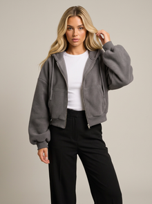 Woman wearing dark grey cropped zip-up fleece-lined hoodie
