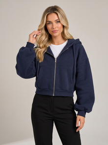 Woman wearing navy blue cropped zip-up fleece-lined hoodie