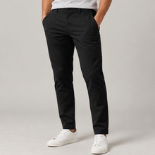 Men's black tailored stretch tapered pants, full-length standing studio view