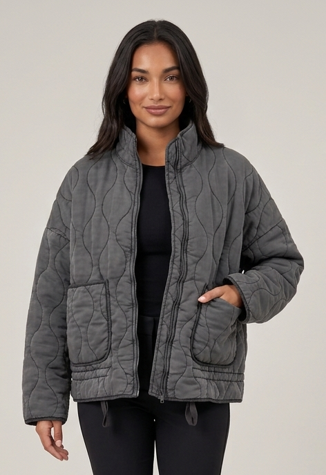 Women's dark grey quilted funnel neck jacket walking pose