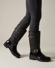 Black quilted waterproof mid-calf rain boots, on-model side view